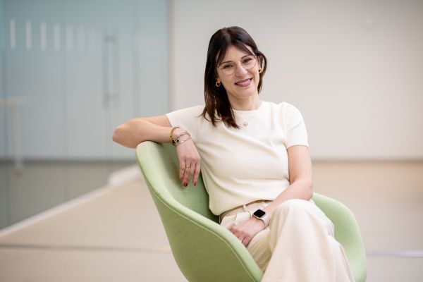 a woman sitting in a green chair, looking at the camera