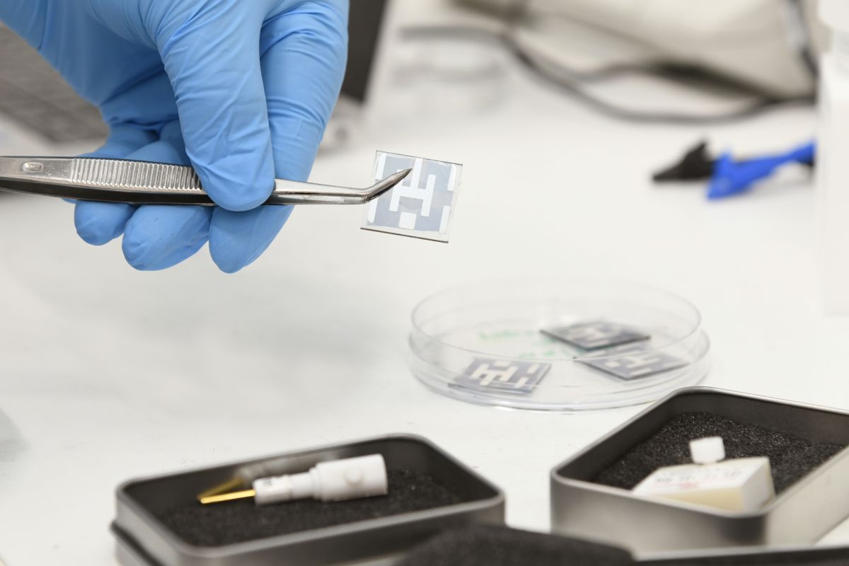Een hand in een blauwe handschoen in het Hydrogen lab.