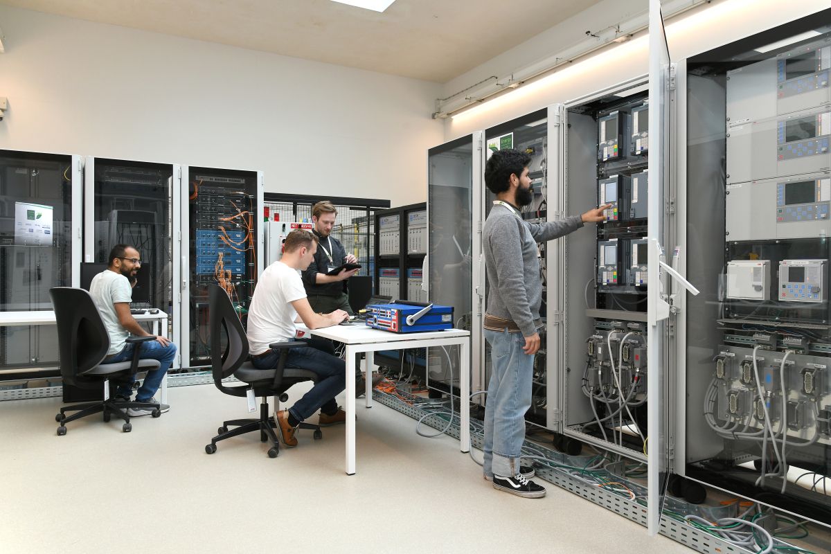 3 people working in the Digital Grid Emulation Lab.