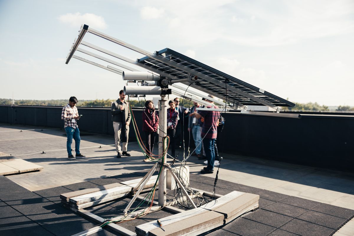 Meerdere personen kijken naar de zonnepanelen in het Outdoor Metrologielab.