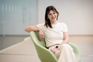 a woman sitting in a green chair, looking at the camera