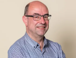 A man with glasses looking at the camera