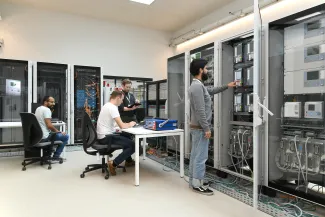 3 people working in the Digital Grid Emulation Lab.
