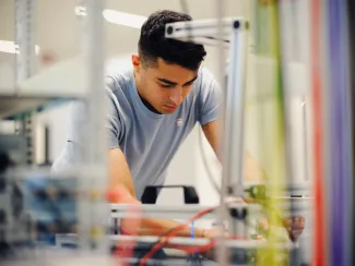 A man is working in a lab, looking down, away from the camera.