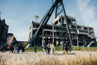 People walking in front of the mine shaft.