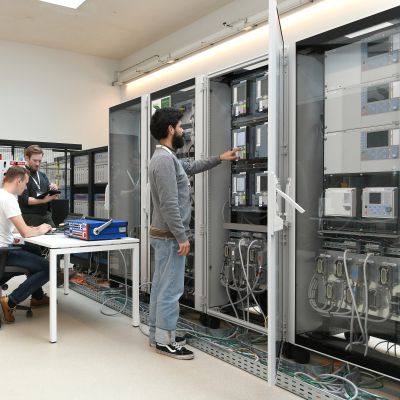 3 people working in the Digital Grid Emulation Lab.