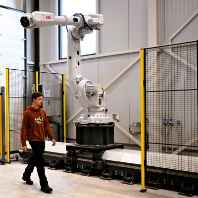 Man wandelt langs de robotarm in het roboticalab.