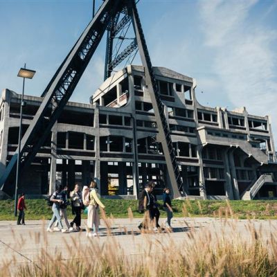 People walking in front of the mine shaft.
